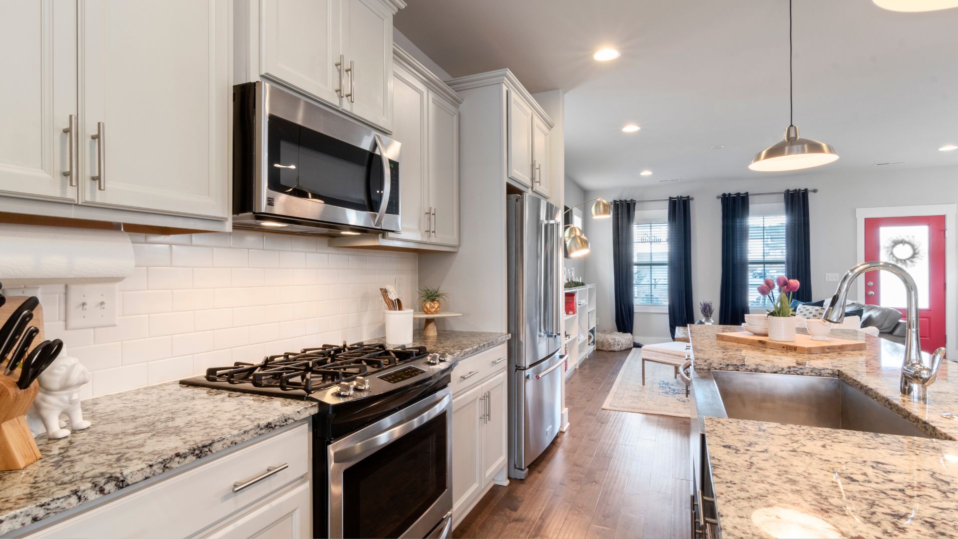Modern kitchen with white cabinets, granite counters, and stainless steel appliances
